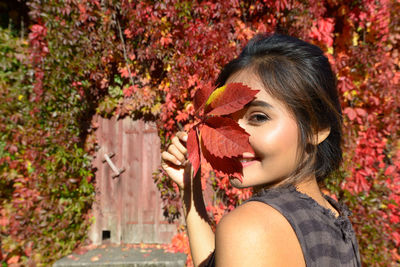 Portrait of smiling young woman with autumn leaves