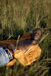 Portrait of young man laying on the field