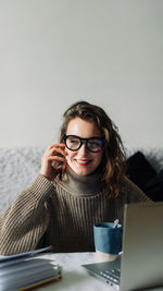 Portrait of young woman using laptop at home