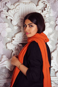Portrait of young woman standing against white background