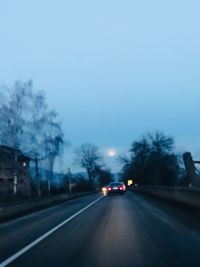 Cars on street against sky during winter