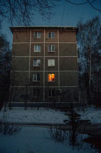 House by bare trees on snow covered building