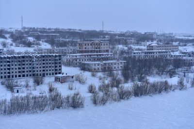 Buildings in city against sky during winter