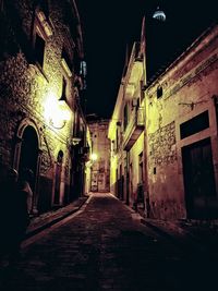 Street amidst buildings at night