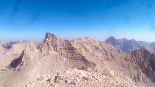 Panoramic view of mountains against clear blue sky