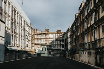 Road amidst buildings in city against sky