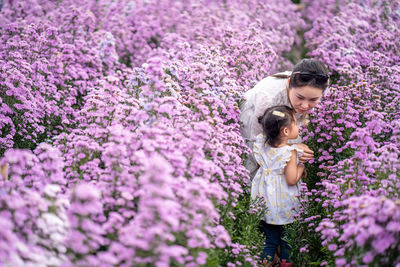 Woman standing on purple flowering plants