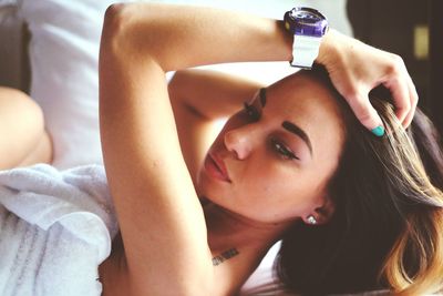 Close-up of young woman relaxing on bed