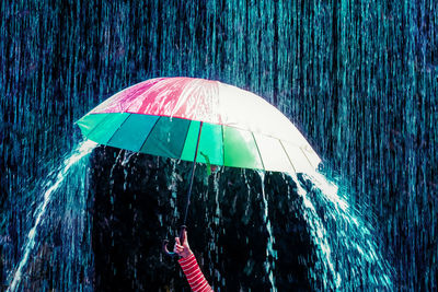 Cropped hand of woman holding umbrella during monsoon