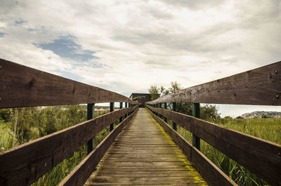 Footbridge over water against sky