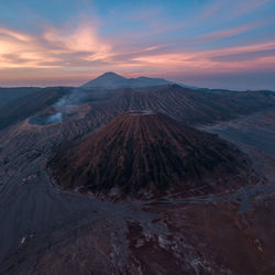 Scenic view of mountains against cloudy sky during sunset