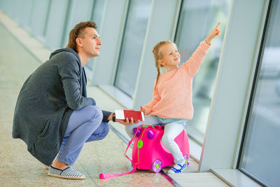 Full length of father holding passport at airport