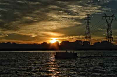 Silhouette boat in sea against sky during sunset