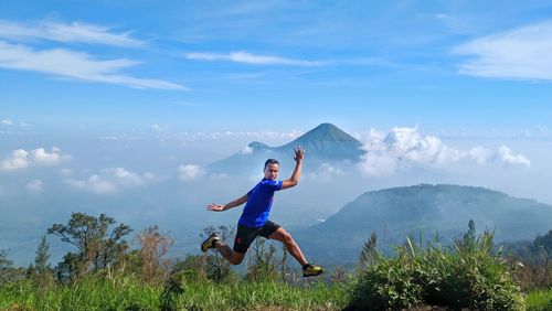 Full length of man jumping against sky