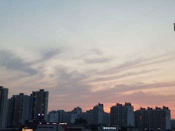 Buildings in city against sky during sunset