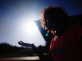 Silhouette woman gesturing against sky