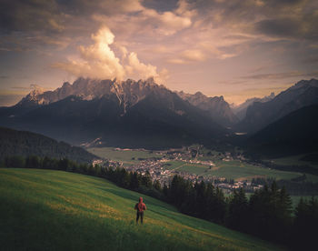 Rear view of man on field against mountains