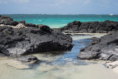 Rocks on beach against sky