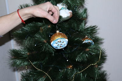 Cropped hand decorating christmas tree