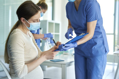 Midsection of doctor examining patient at clinic
