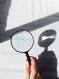 Cropped image of person holding magnifying glass