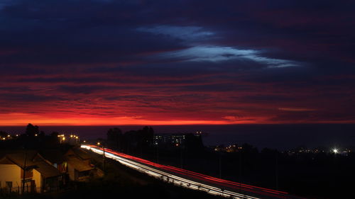 High angle view of light trails on road in city during sunset