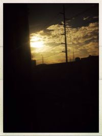 Silhouette of power lines against sunset sky