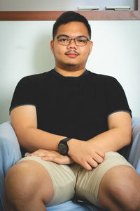 Portrait of young man sitting at home