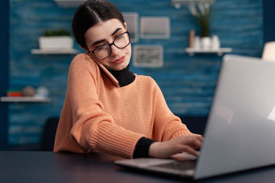 Young woman using laptop at table