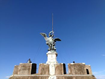 Low angle view of statue against blue sky