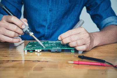 Midsection of man working on table