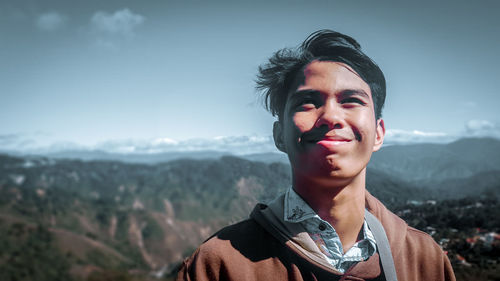 Man making face against mountains