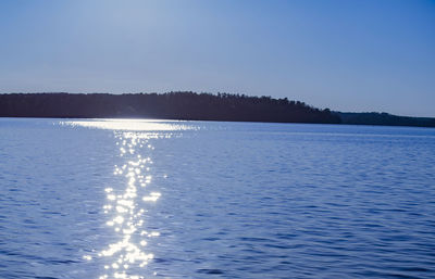 Scenic view of lake against clear blue sky