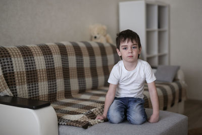 Toddler child sad on the couch in the real room at home, lifestyles and toning