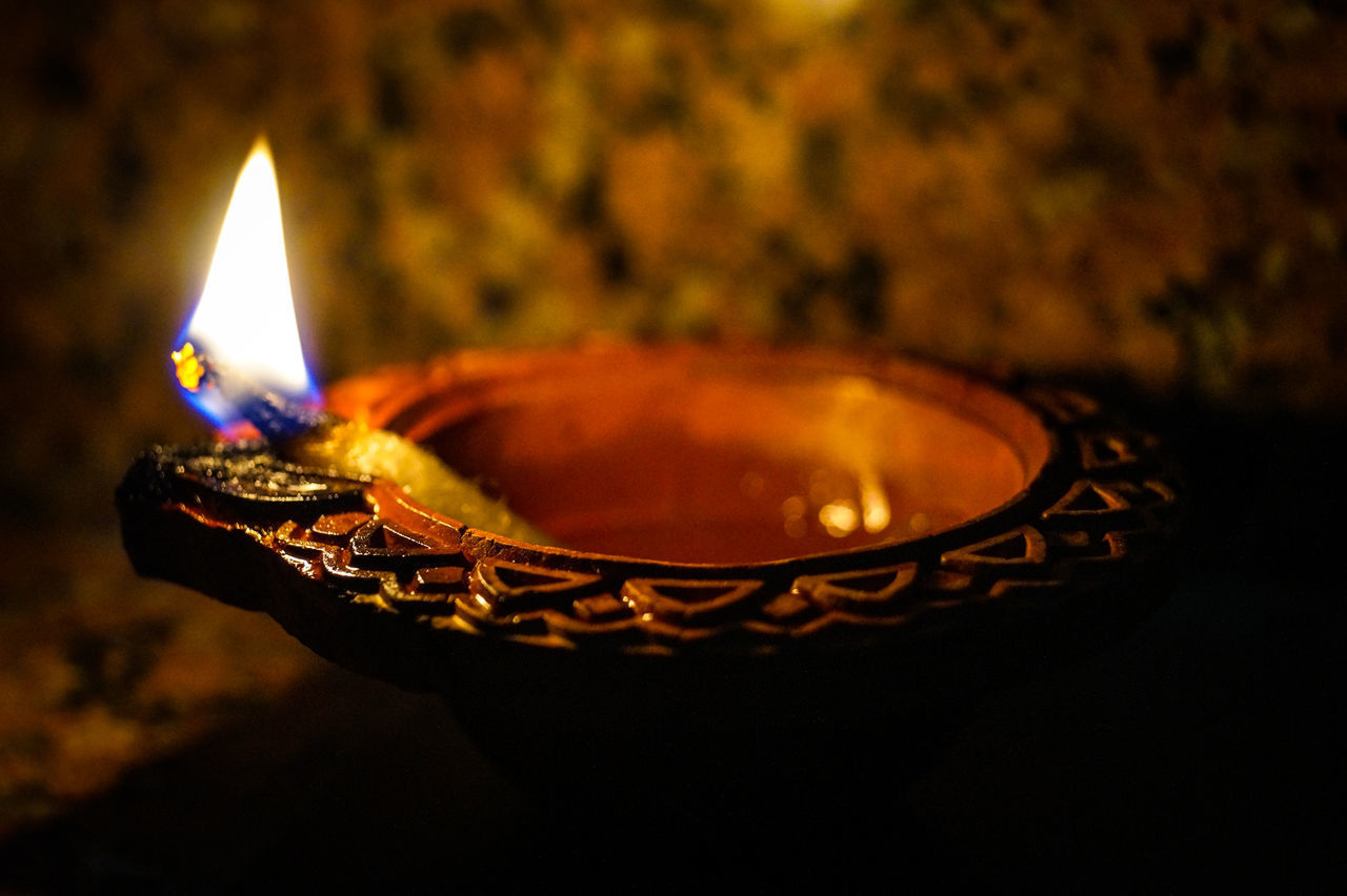 CLOSE-UP OF ILLUMINATED LIGHT CANDLE