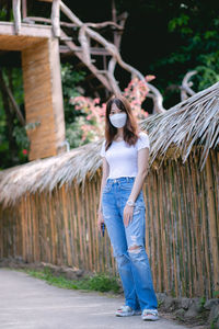 Young woman standing against wall