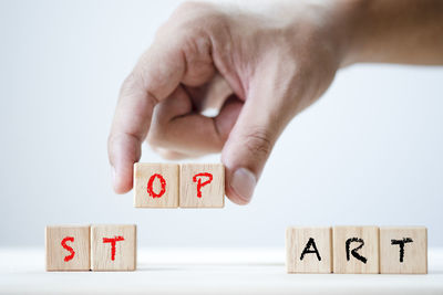 Close-up of hand holding toy against white background