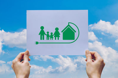 Midsection of person holding hands against blue sky