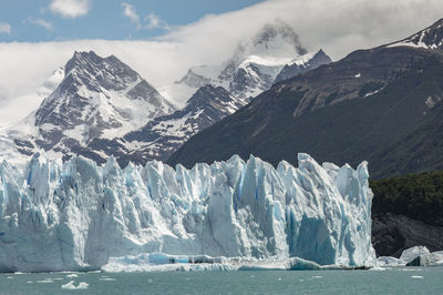 Scenic view of glacier with mountains in the background.