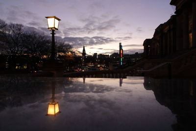 Reflection of illuminated buildings in water at dusk