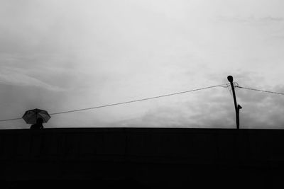 Low angle view of silhouette pole against sky