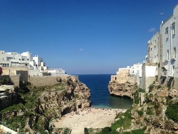 Panoramic view of sea and buildings against clear blue sky