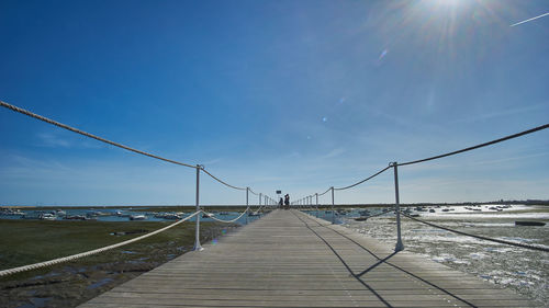 Bridge over sea against blue sky