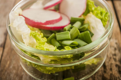 Close-up of fresh salad in glass bowl on table