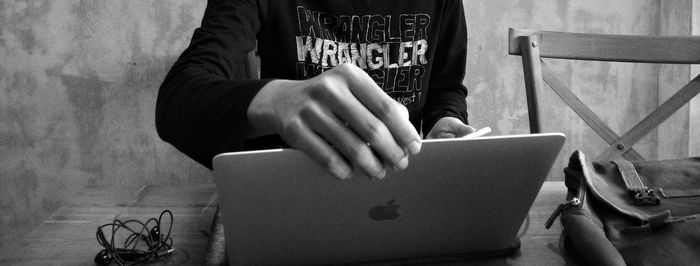 Midsection of man using mobile phone at home