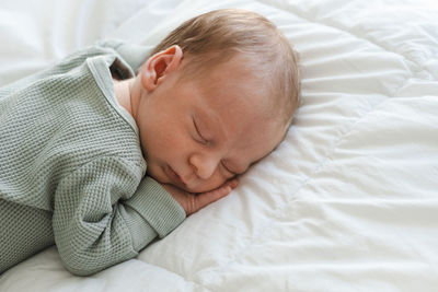 High angle view of newborn boy sleeping on bed at home