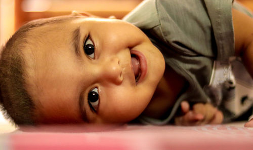 Portrait of cute baby lying on bed