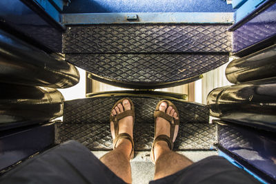 Low section of man standing in train