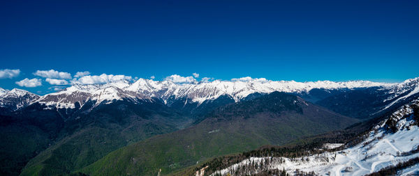 Scenic view of snowcapped mountains against clear blue sky