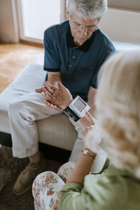 Senior couple taking blood pressure at home